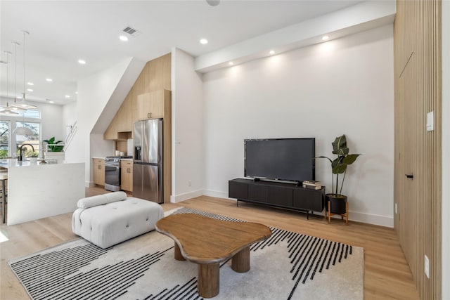 living room featuring light wood-style flooring, recessed lighting, visible vents, and baseboards