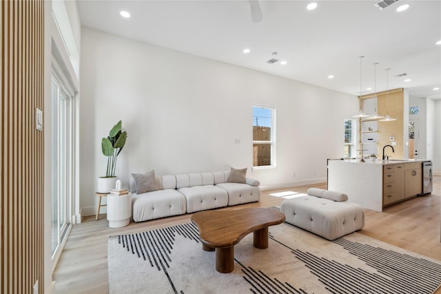 living room featuring light wood finished floors, visible vents, and recessed lighting