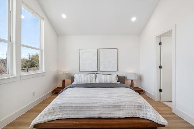 bedroom featuring recessed lighting, light wood-style flooring, baseboards, and lofted ceiling