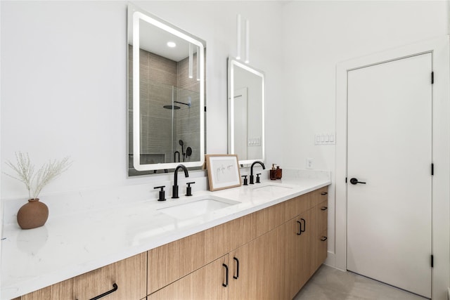 full bathroom featuring a sink, a stall shower, and double vanity