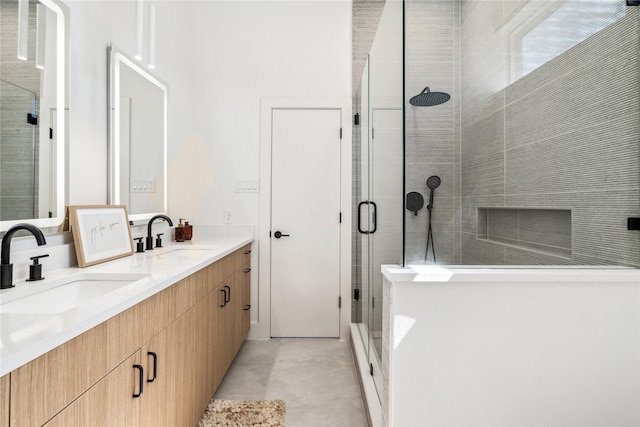 full bathroom with a sink, a stall shower, and double vanity