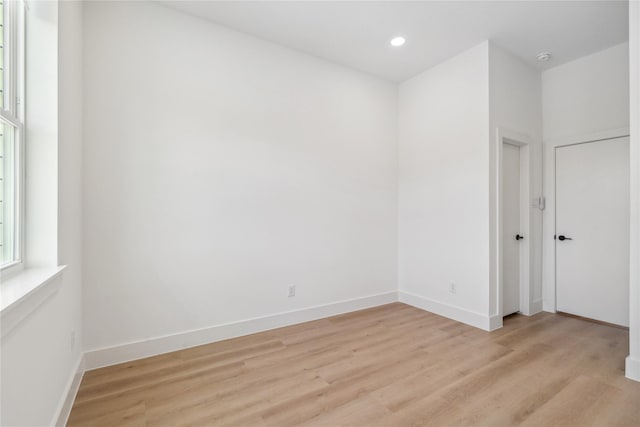 spare room with recessed lighting, light wood-type flooring, and baseboards