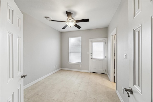 spare room with baseboards and a ceiling fan