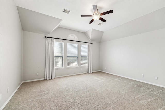 spare room featuring visible vents, lofted ceiling, ceiling fan, and carpet floors