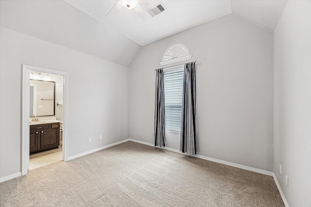 unfurnished bedroom with lofted ceiling, visible vents, baseboards, and light carpet