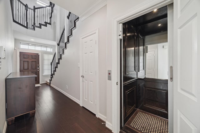 entryway featuring ornamental molding, dark wood-style floors, elevator, baseboards, and stairs