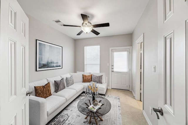 living room featuring visible vents, baseboards, and a ceiling fan