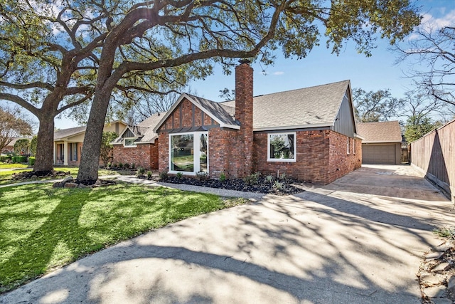 view of front of home featuring brick siding, a chimney, a front yard, and a shingled roof