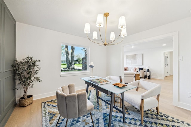 dining room with a notable chandelier, baseboards, and light wood-style floors