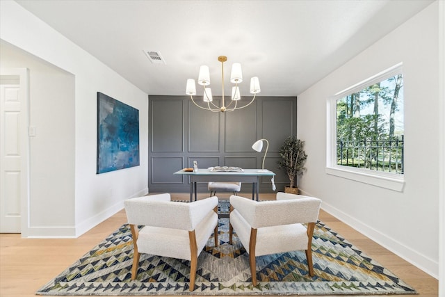 dining space featuring a notable chandelier, baseboards, visible vents, and light wood-type flooring