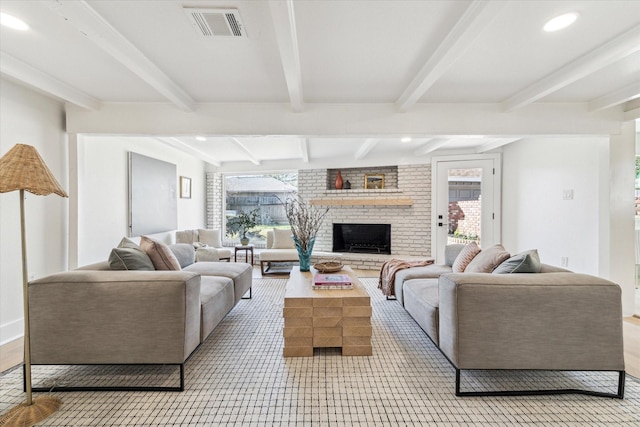 living area featuring recessed lighting, visible vents, beamed ceiling, and a fireplace