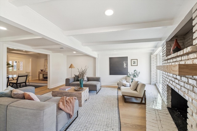 living area featuring beam ceiling, recessed lighting, a brick fireplace, and light wood-style floors