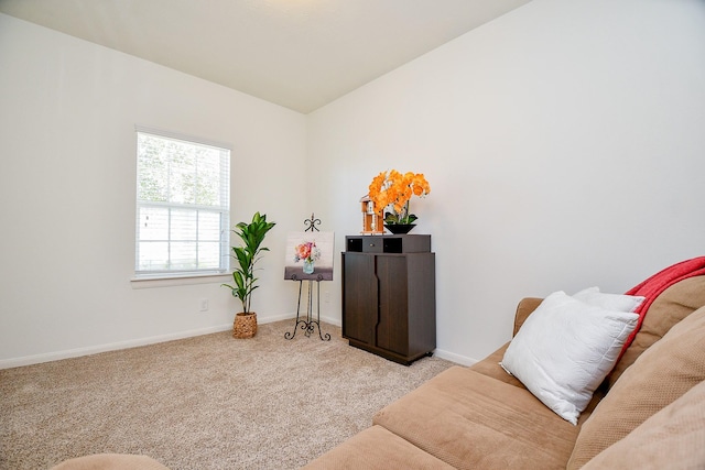 living area with baseboards, lofted ceiling, and carpet flooring