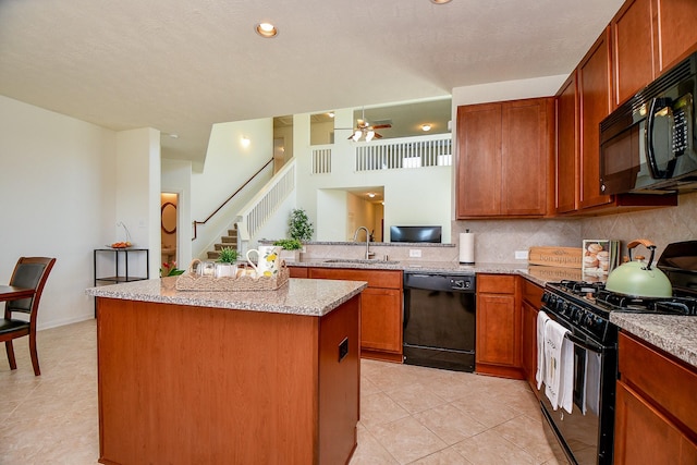 kitchen featuring black appliances, a ceiling fan, a sink, a center island, and decorative backsplash