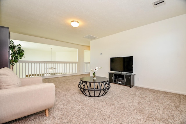 carpeted living area featuring visible vents and baseboards