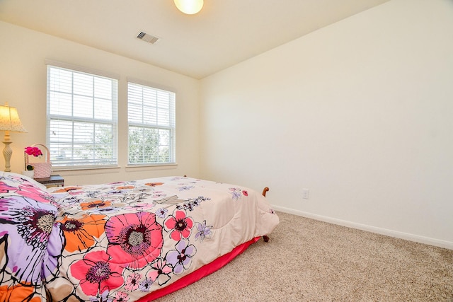 bedroom featuring visible vents, baseboards, and carpet