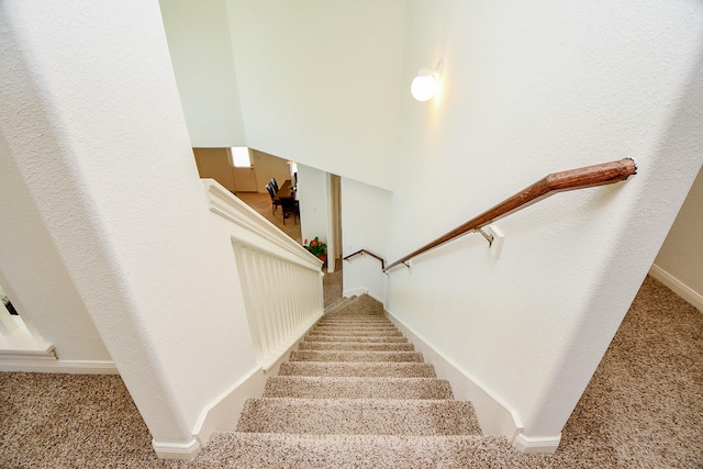 staircase with baseboards and carpet