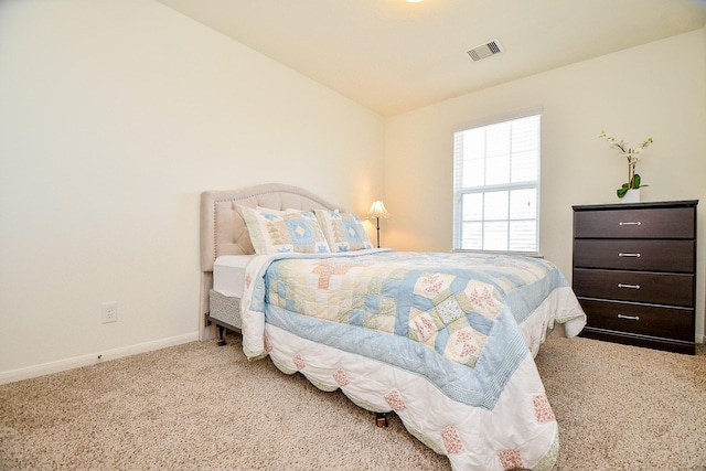 carpeted bedroom with visible vents and baseboards