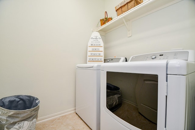 laundry area featuring washer and dryer, baseboards, laundry area, and light tile patterned floors