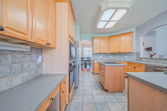 kitchen with arched walkways, backsplash, appliances with stainless steel finishes, and light brown cabinetry