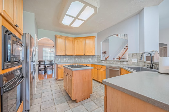 kitchen with tasteful backsplash, light brown cabinets, arched walkways, black appliances, and a sink