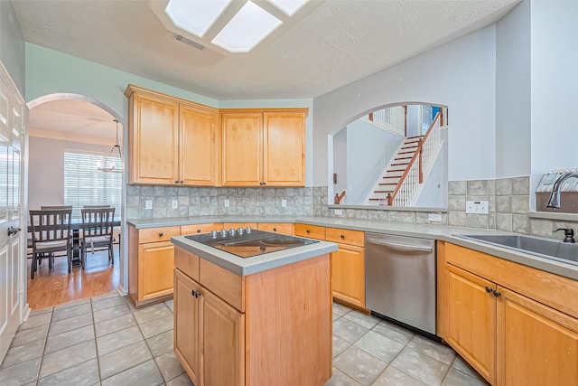 kitchen featuring arched walkways, a sink, light brown cabinetry, stainless steel dishwasher, and black electric cooktop