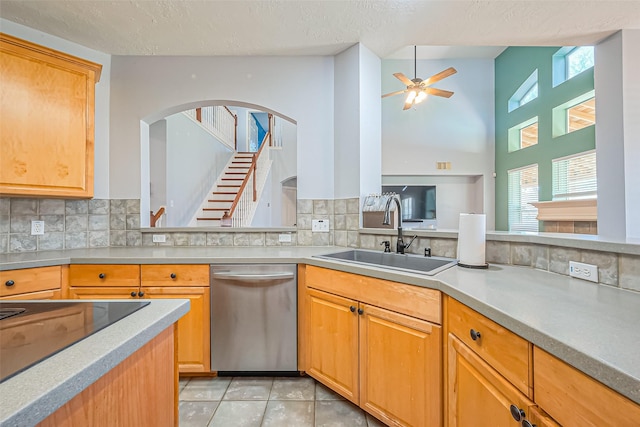 kitchen featuring light tile patterned floors, ceiling fan, a sink, light countertops, and stainless steel dishwasher