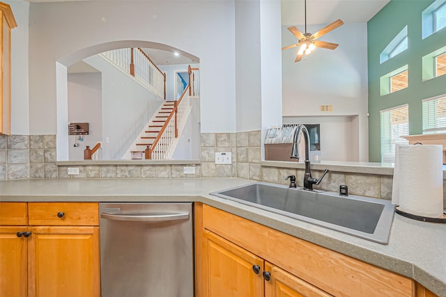 kitchen featuring backsplash, ceiling fan, dishwasher, light countertops, and a sink