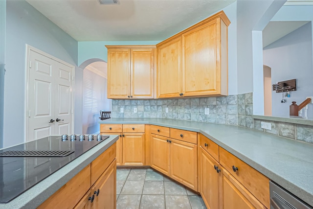 kitchen featuring tasteful backsplash, arched walkways, light tile patterned flooring, light countertops, and black electric stovetop