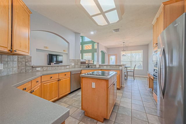 kitchen featuring decorative backsplash, visible vents, appliances with stainless steel finishes, and a sink