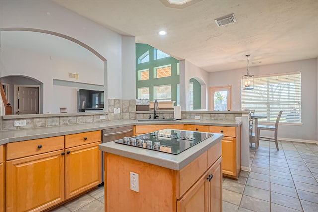 kitchen featuring a sink, visible vents, black electric stovetop, and light countertops