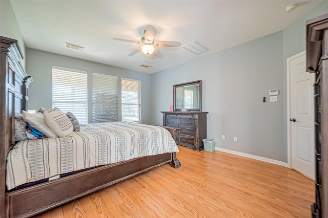 bedroom featuring light wood finished floors, visible vents, ceiling fan, and baseboards