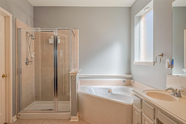 bathroom featuring a garden tub, a stall shower, vanity, and tile patterned flooring