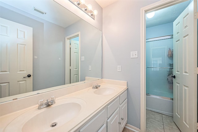 bathroom featuring tile patterned flooring, visible vents, double vanity, and a sink