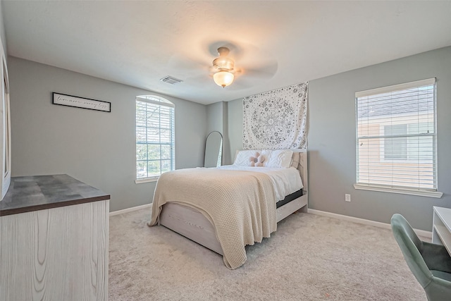 carpeted bedroom with baseboards, visible vents, and ceiling fan