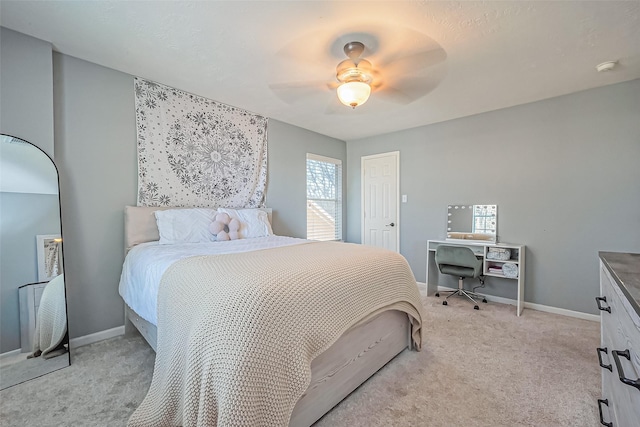 bedroom with light colored carpet, baseboards, and ceiling fan