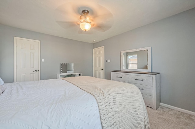 bedroom featuring a ceiling fan, light colored carpet, and baseboards