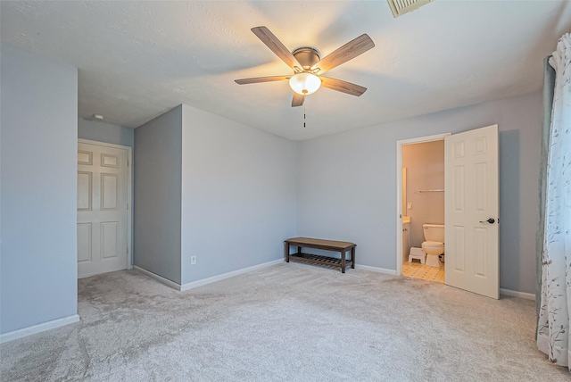 carpeted empty room with visible vents, baseboards, and ceiling fan