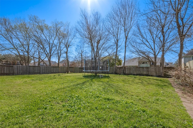 view of yard with a fenced backyard and a trampoline