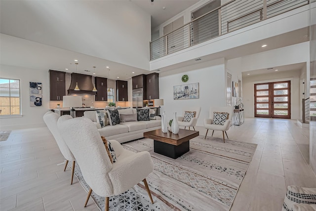 living area featuring recessed lighting, visible vents, and a high ceiling