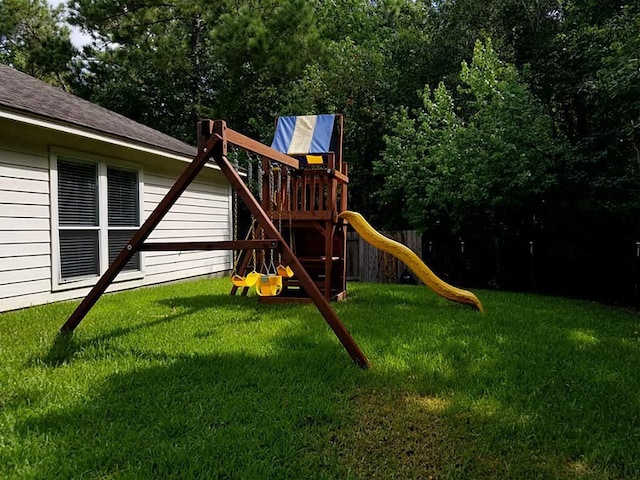 view of playground with a yard and fence