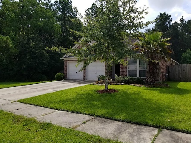 obstructed view of property with brick siding, fence, a front yard, a garage, and driveway