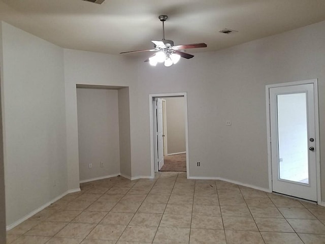 spare room featuring light tile patterned floors, baseboards, visible vents, and ceiling fan