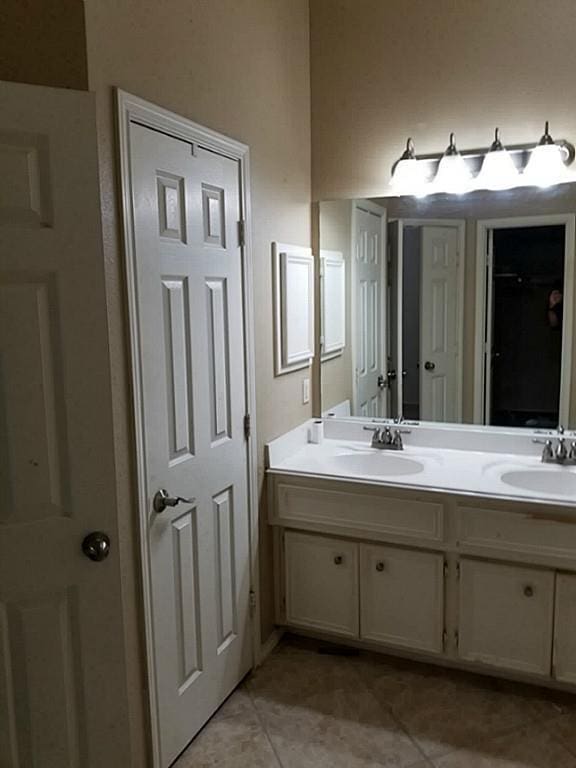 full bathroom featuring double vanity, tile patterned floors, and a sink