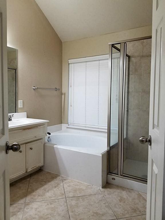 bathroom with vanity, a stall shower, tile patterned flooring, vaulted ceiling, and a garden tub