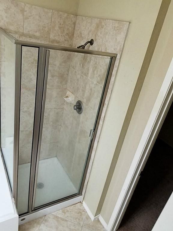 full bathroom featuring tile patterned floors and a stall shower