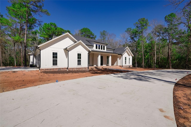 modern farmhouse style home featuring a porch and concrete driveway