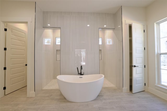 bathroom featuring a soaking tub, a stall shower, and wood finish floors