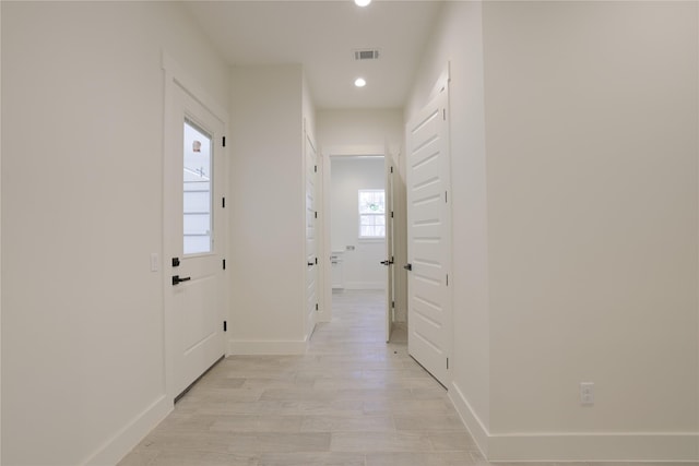 corridor with recessed lighting, visible vents, baseboards, and light wood-style flooring