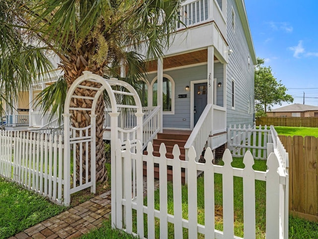 view of front of house featuring fence and covered porch